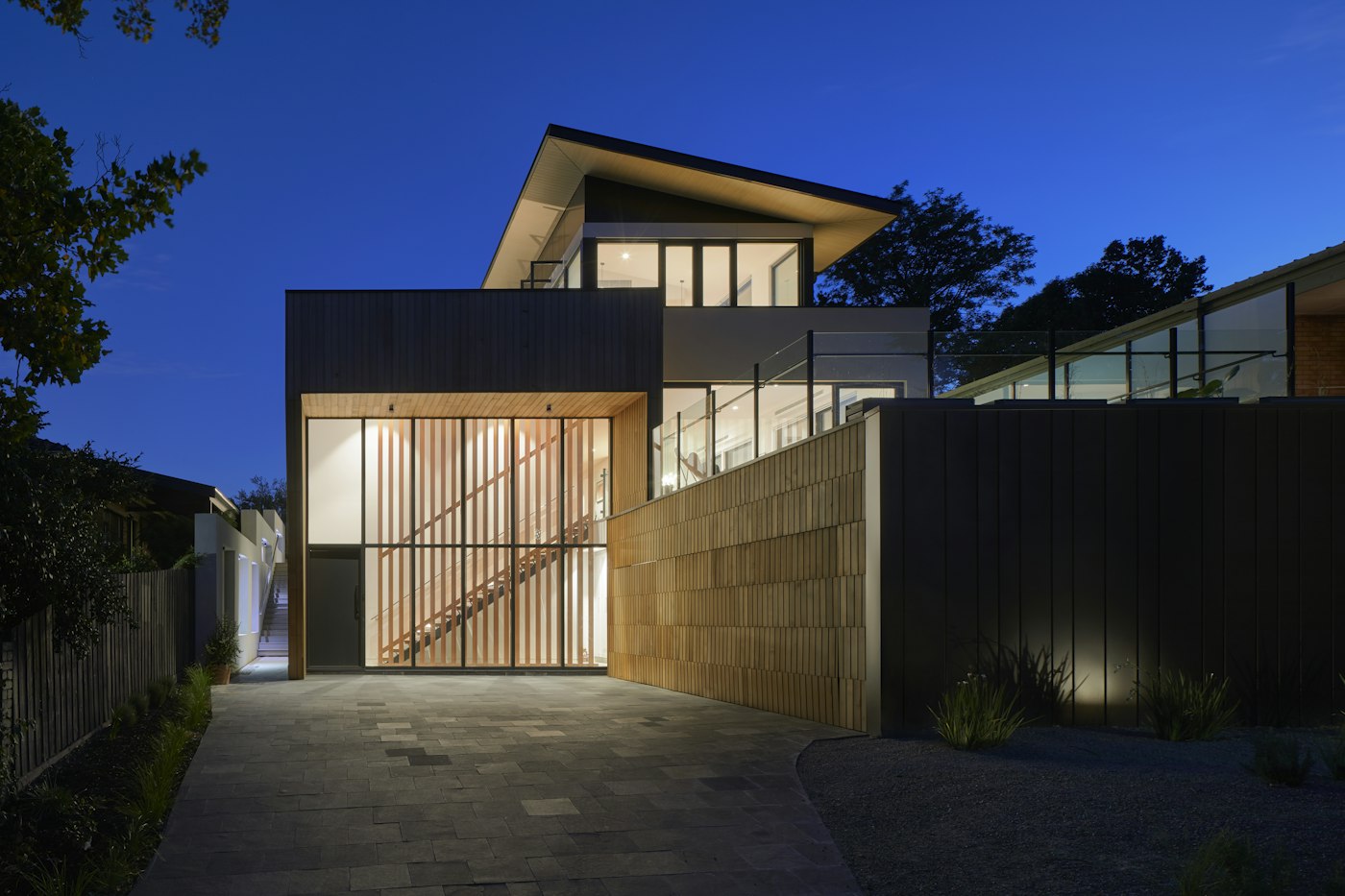 Stone paved driveway leading to a modern home